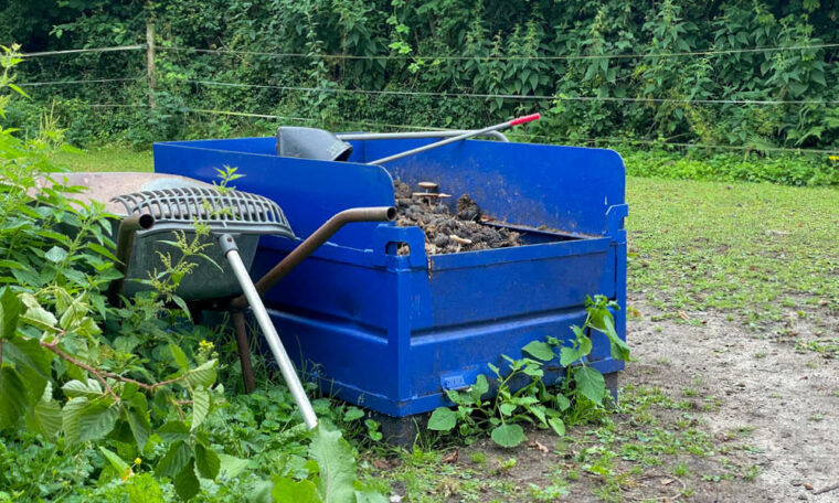 Kleiner Container auf Weide für Pferdemist